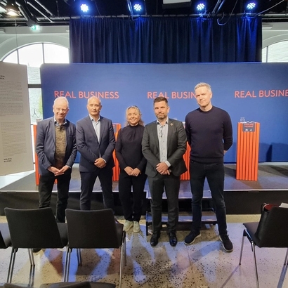 fra arrangement, folk som poserer foran scenen.