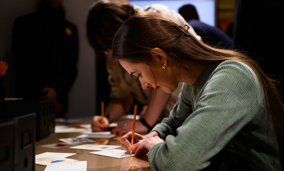 Person som skriver postkort