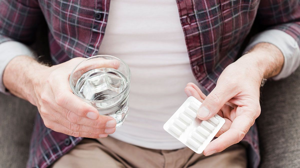 Older adult managing multiple medications, highlighting the risks of complex health plans.