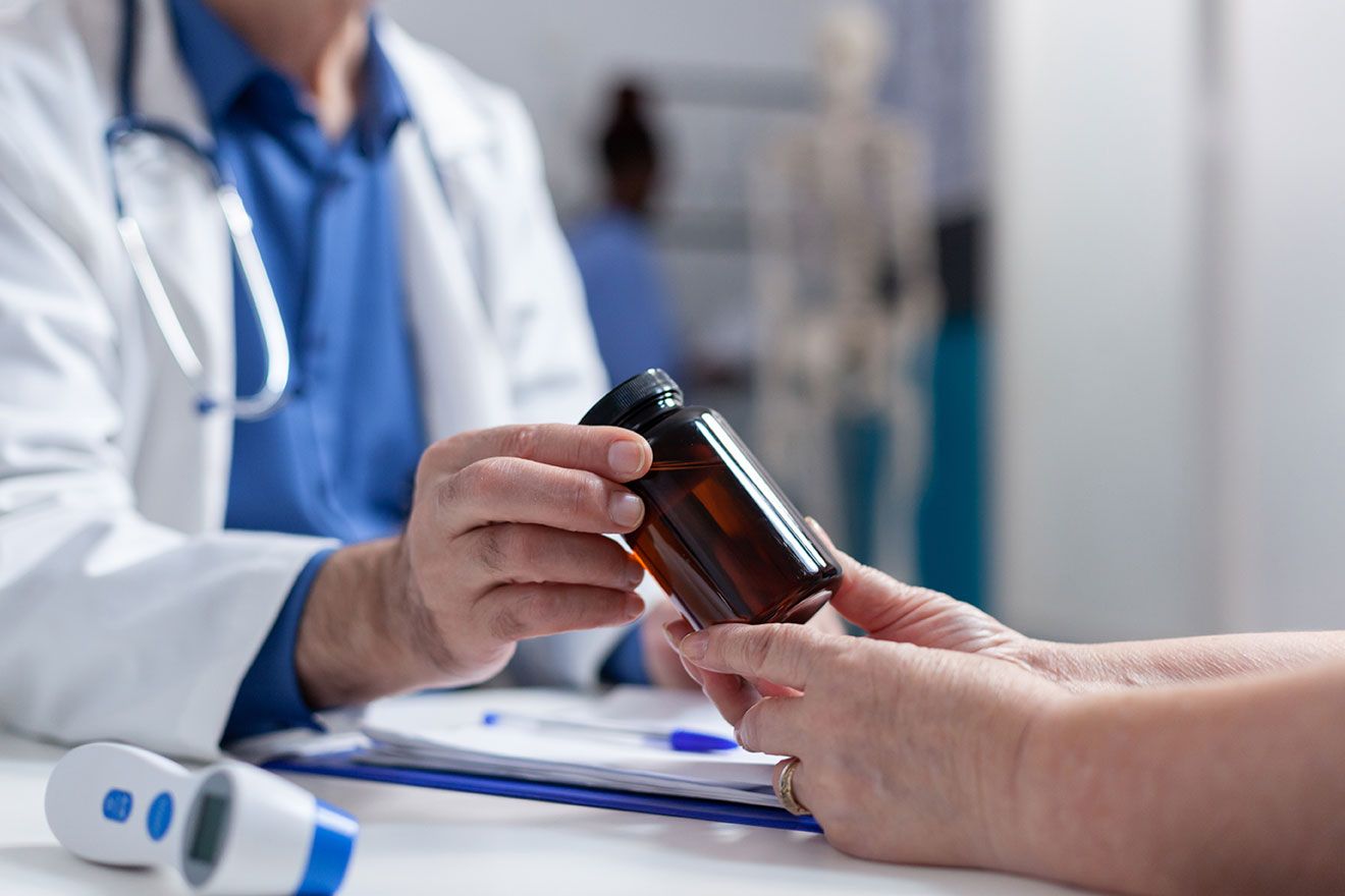 Doctor reviewing medications with a patient as part of simplifying health plans.
