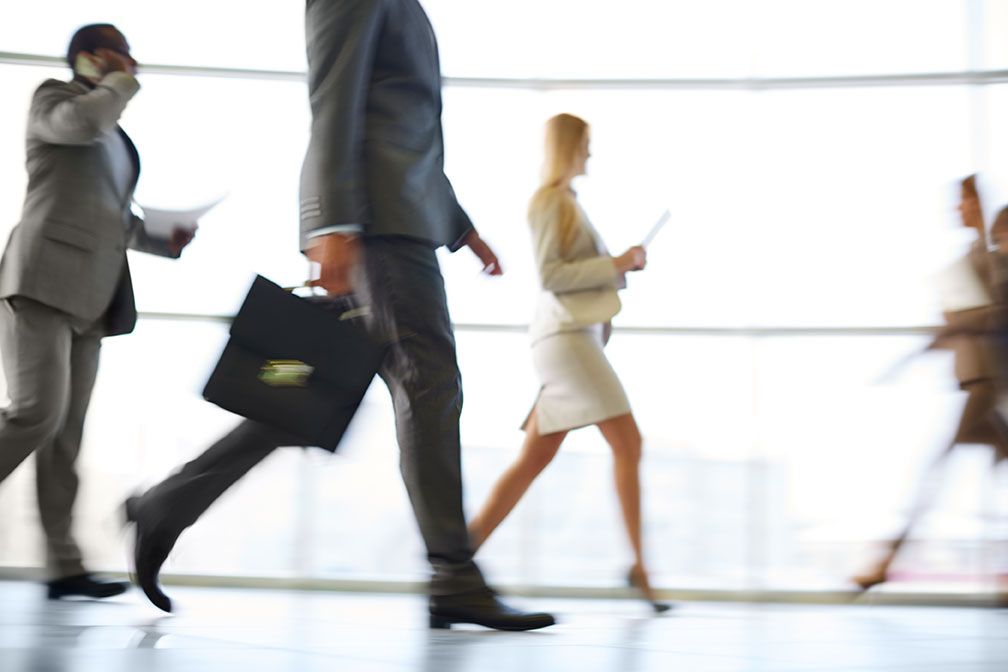 Business professionals walking quickly, symbolizing the need for healthcare for busy professionals.