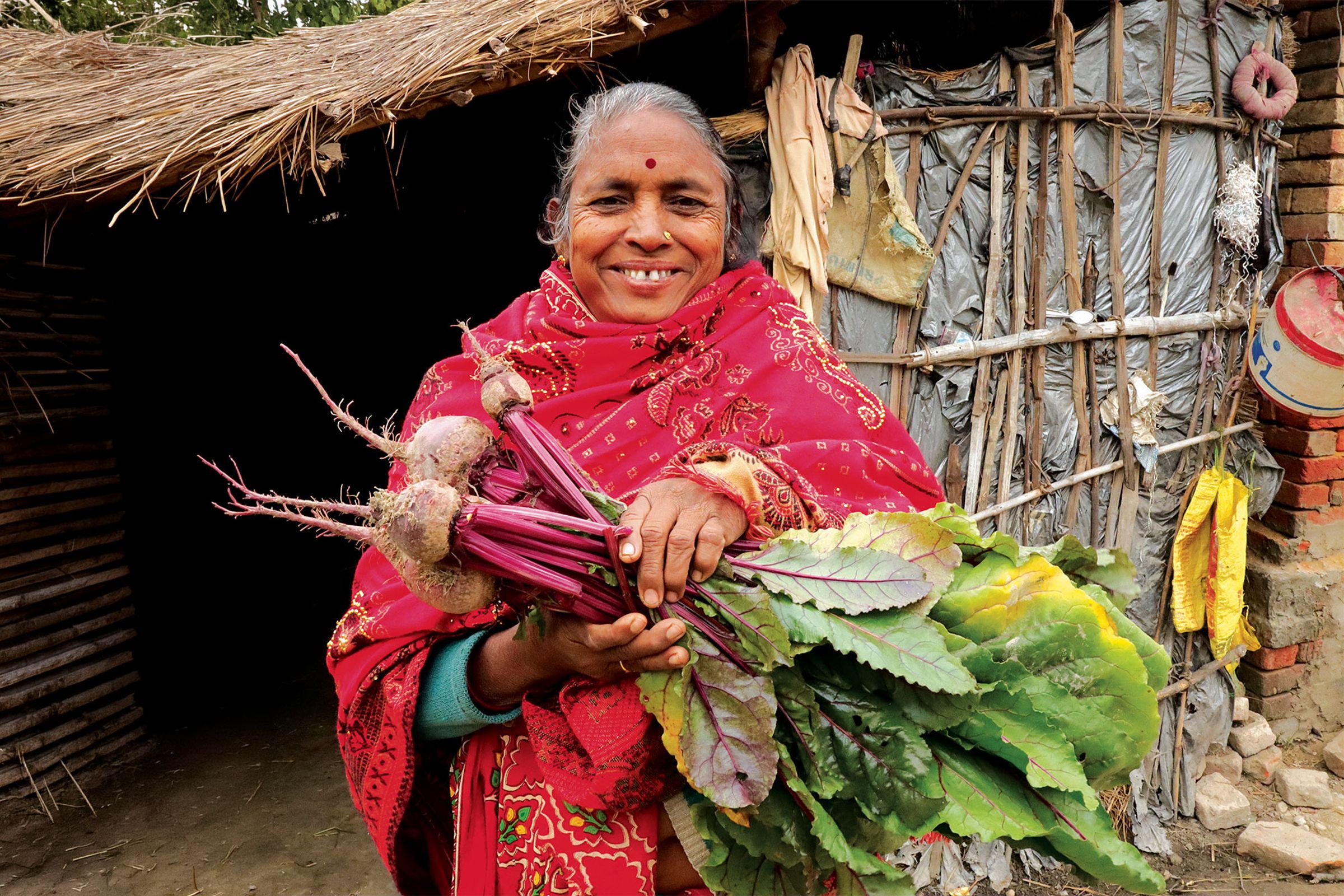 Jagmati smiling as she holds freshly picked beetroot