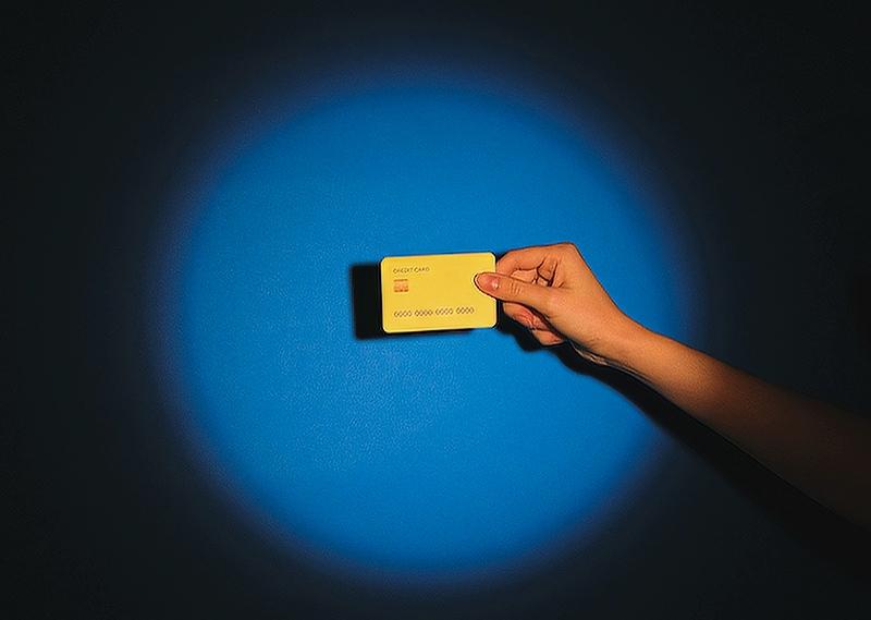 Person holding a credit card in a spotlight