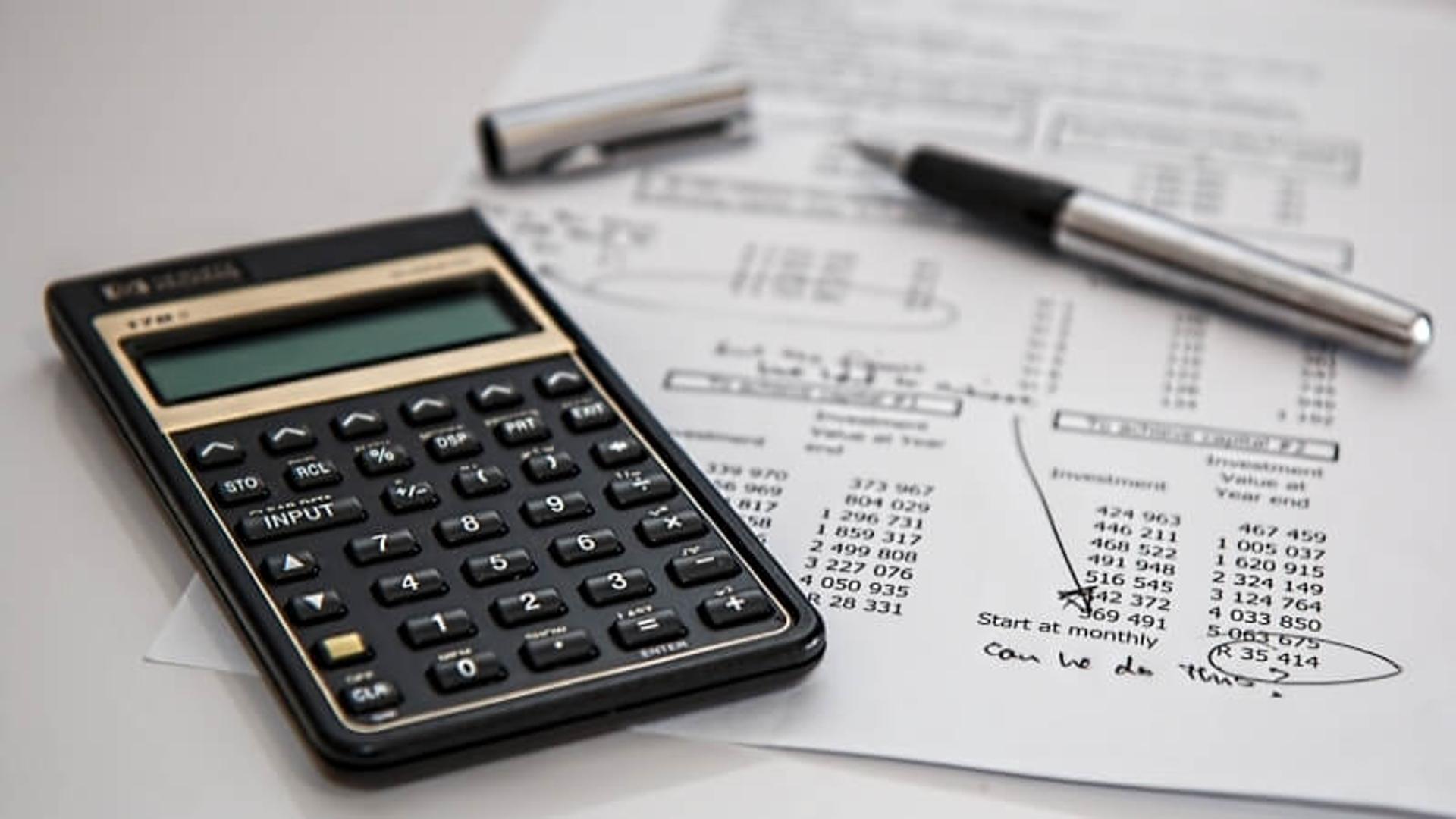 Calculator and pen on top of tax documents