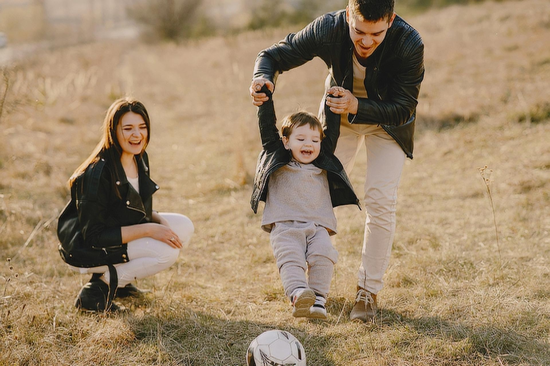 Photograph of a new family playing with their son