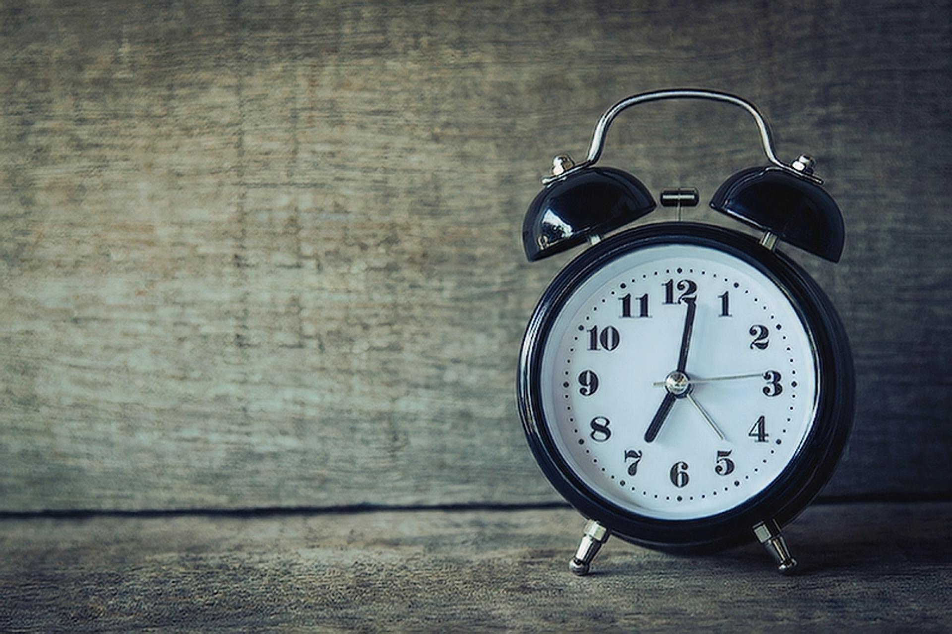 An image of a clock standing on a table.