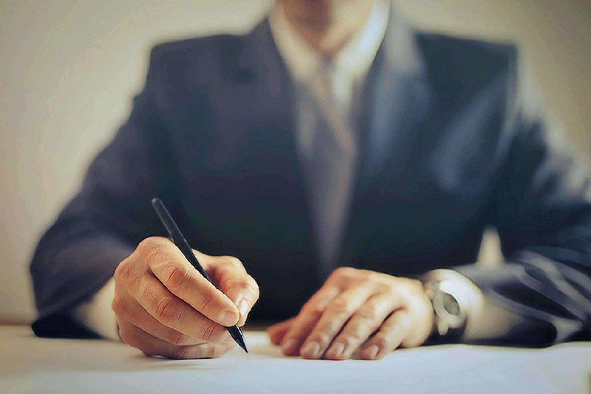 Photograph of businessman signing a document