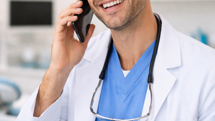 Dentist answering a consultation call in a dental clinic, illustrating how dental marketing can generate consultation calls for dentists.