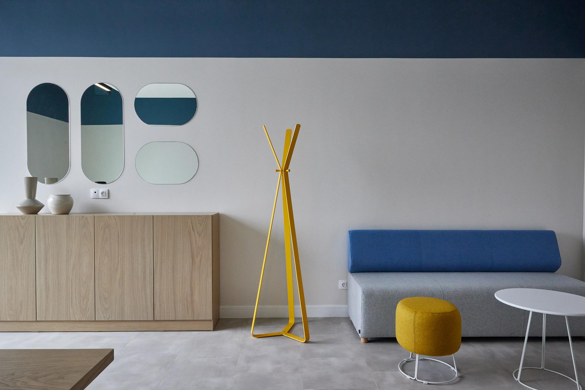 Contemporary open-space office interior at Esentai City Almaty featuring wooden furniture, mirrors and blue sofa - professional interior photography Kazakhstan