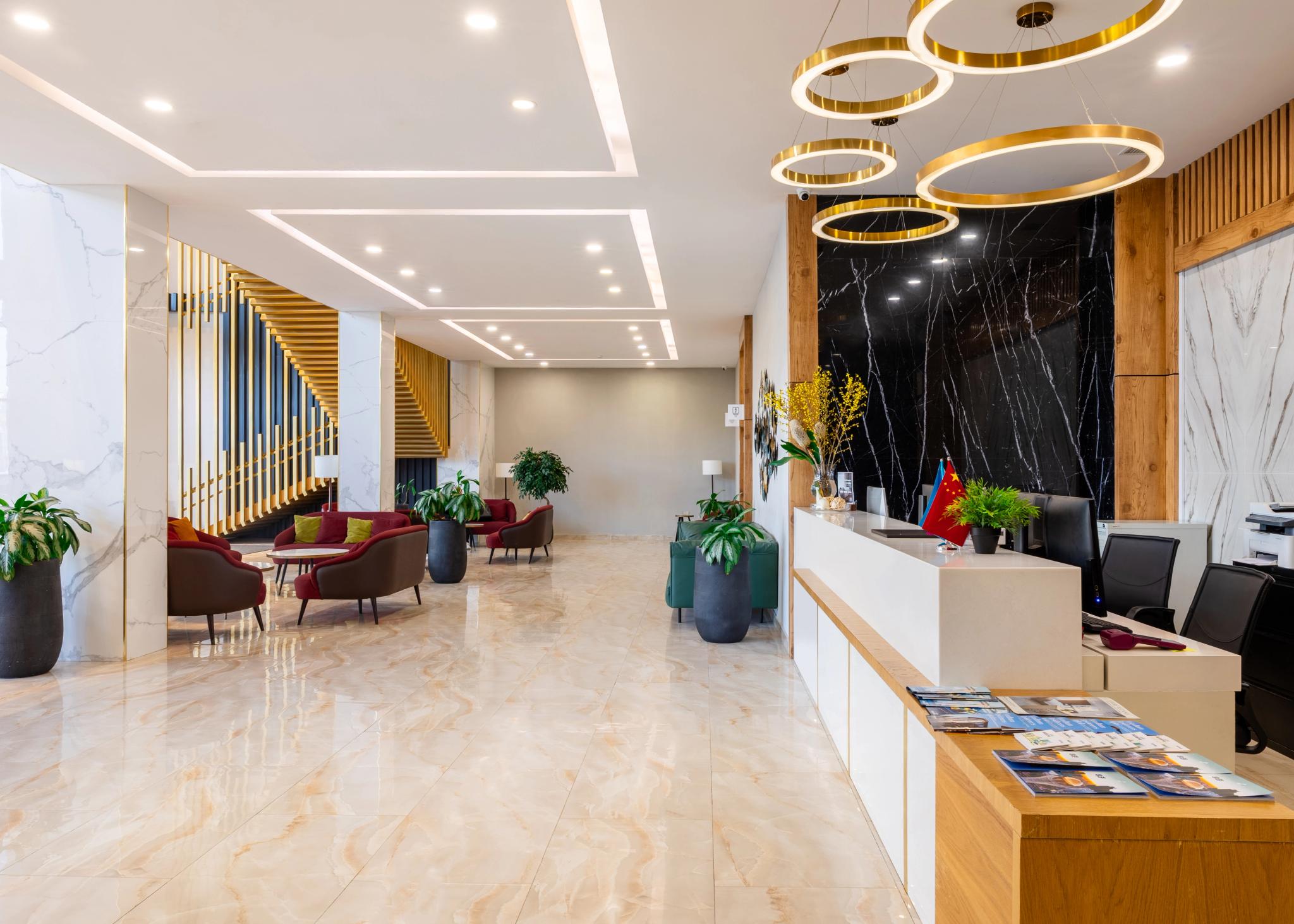 Luxury hotel lobby interior of Tor'Re Astana with marble flooring, golden pendant lights and reception desk - professional interior photography Kazakhstan