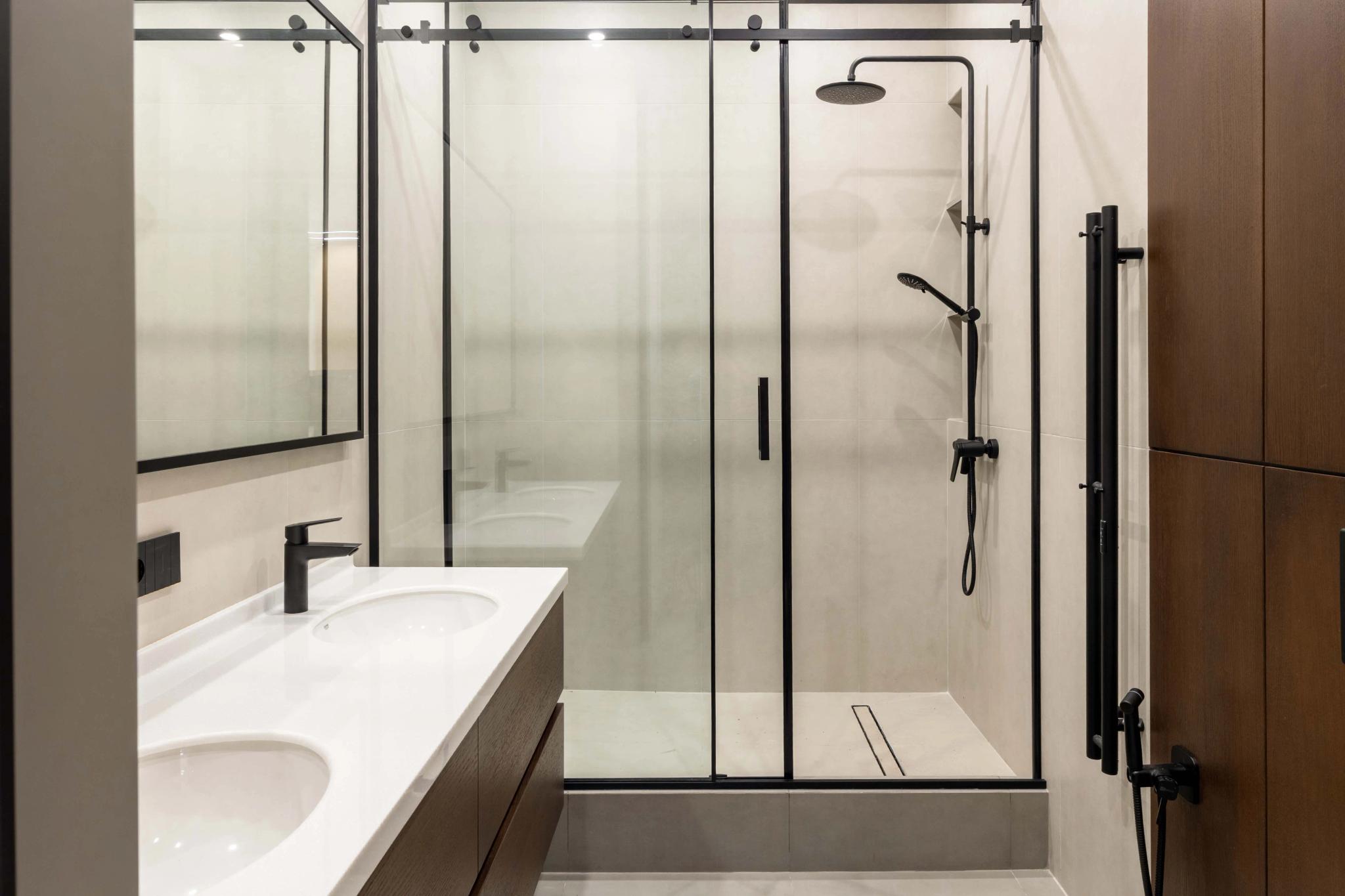 Contemporary bathroom with glass shower enclosure and double vanity, professional interior photography Kazakhstan