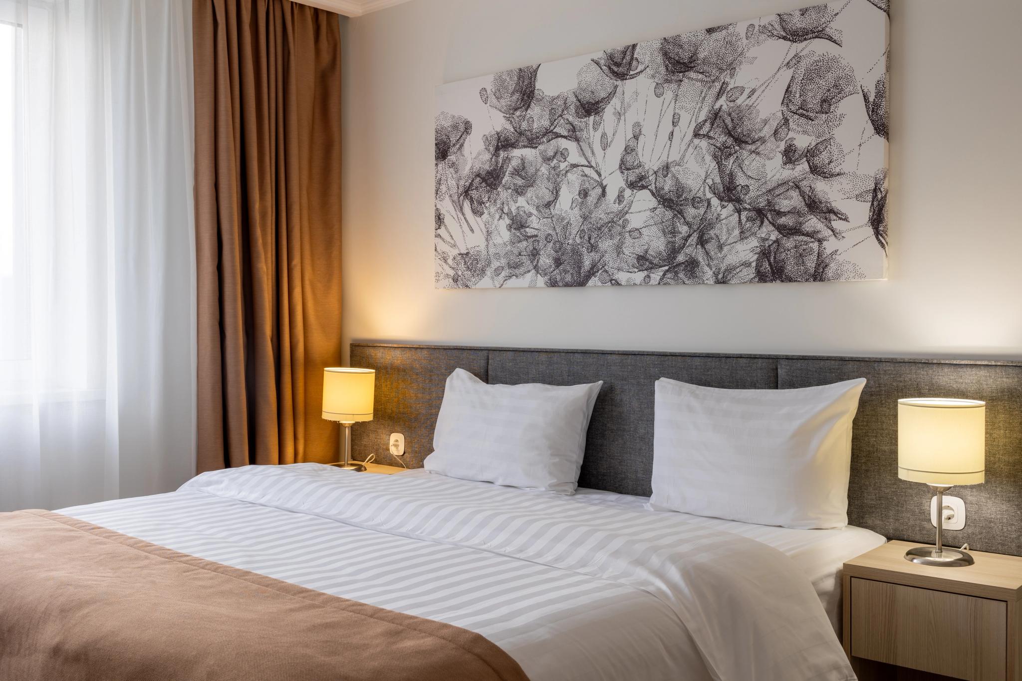 Contemporary hotel room at Tor'Re Astana with double bed, professional hotel interior photography Astana