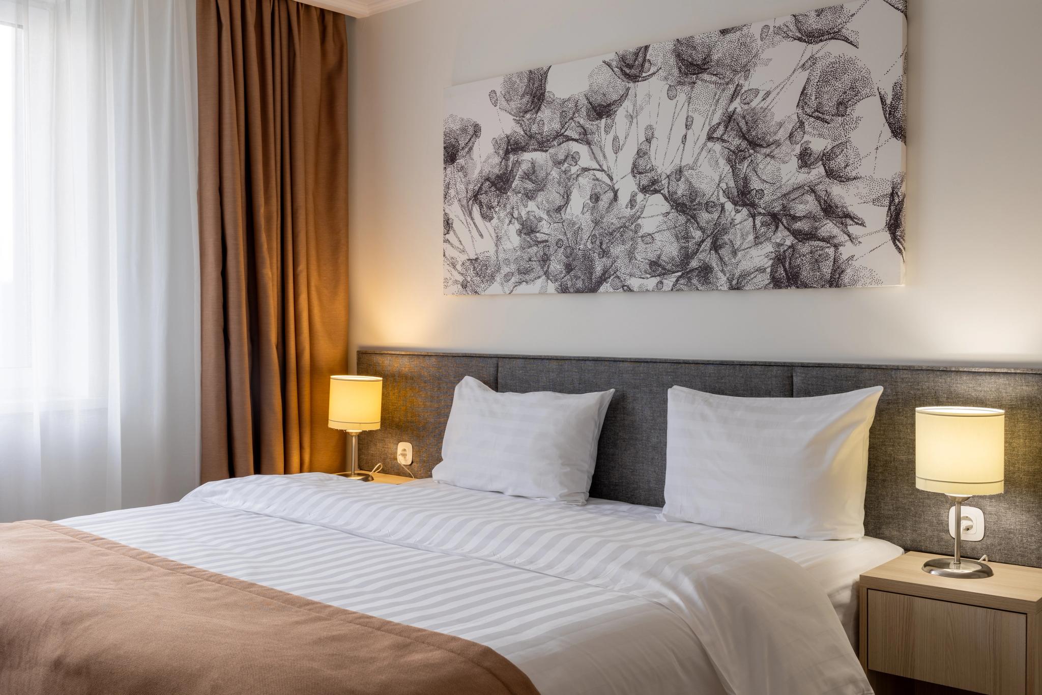 Contemporary hotel room at Tor'Re Astana with double bed, professional hotel interior photography Astana