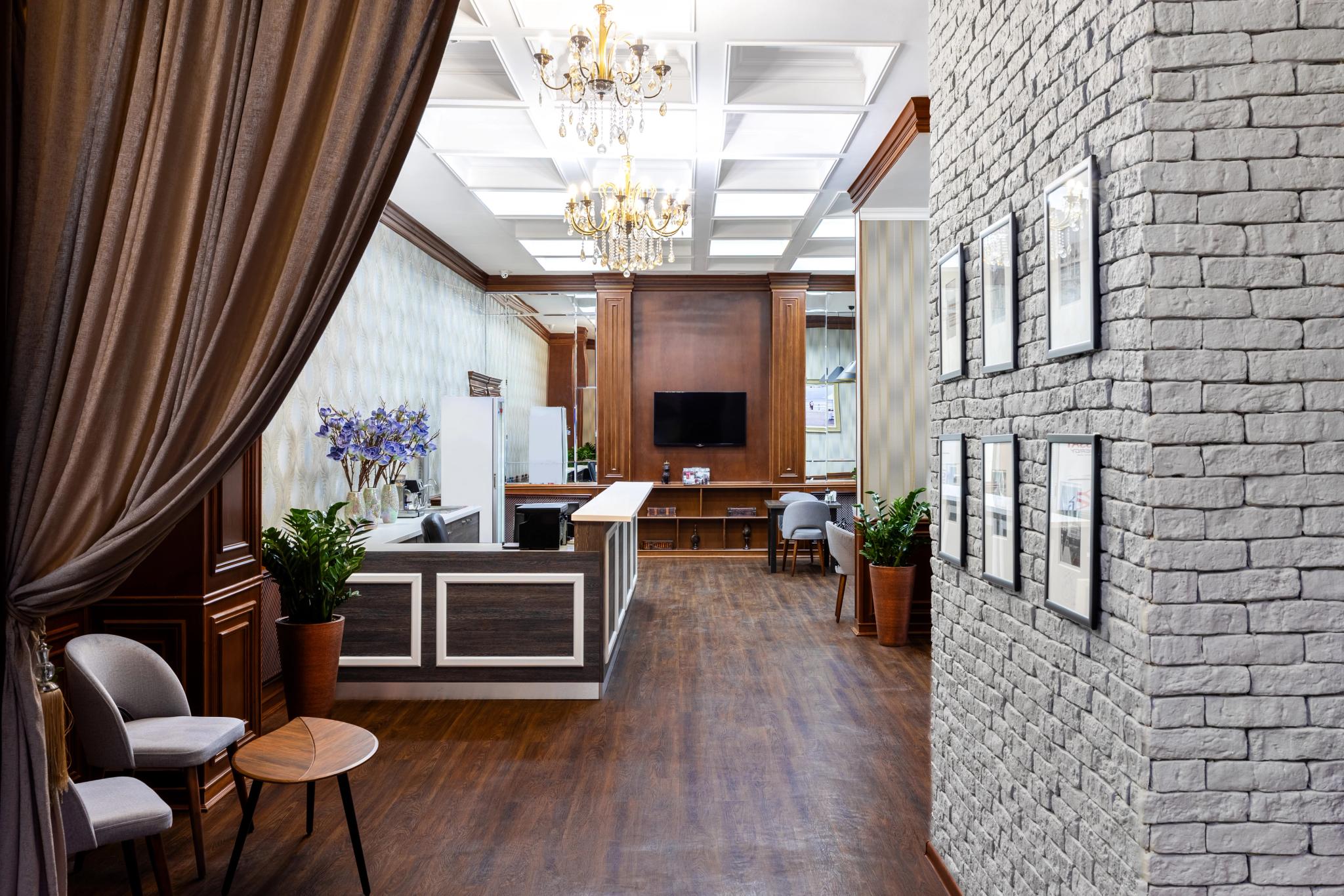 Лаунж-зона лобби отеля Rush Inn в Астане с белой кирпичной стеной и фотографиями — профессиональная интерьерная фотография