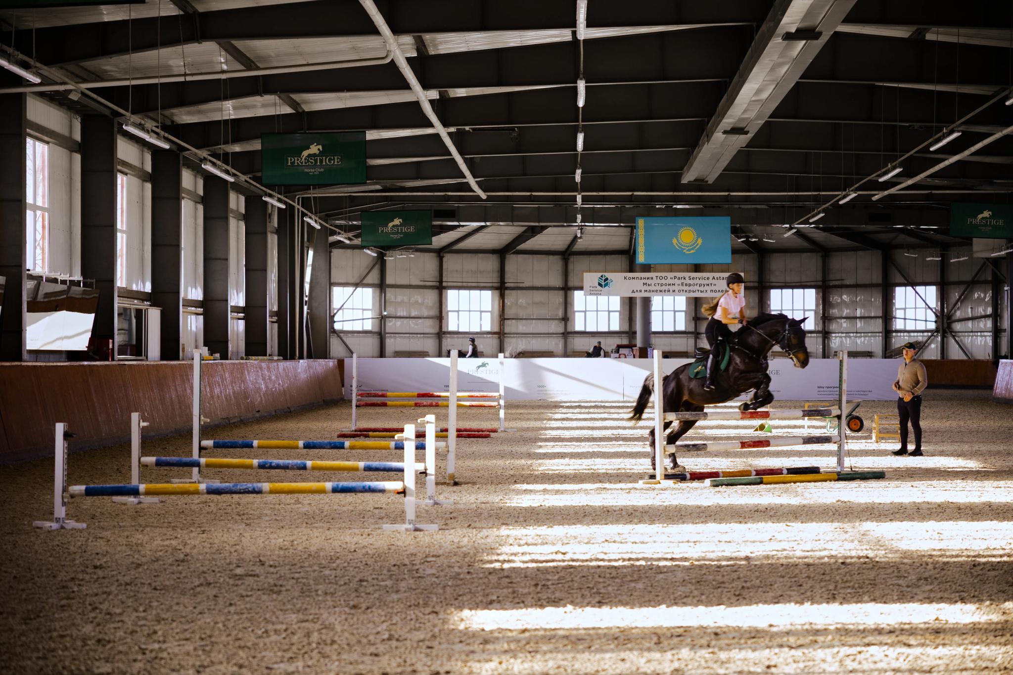 Spacious riding arena of Prestige equestrian club with jumping obstacles, architectural photography Astana