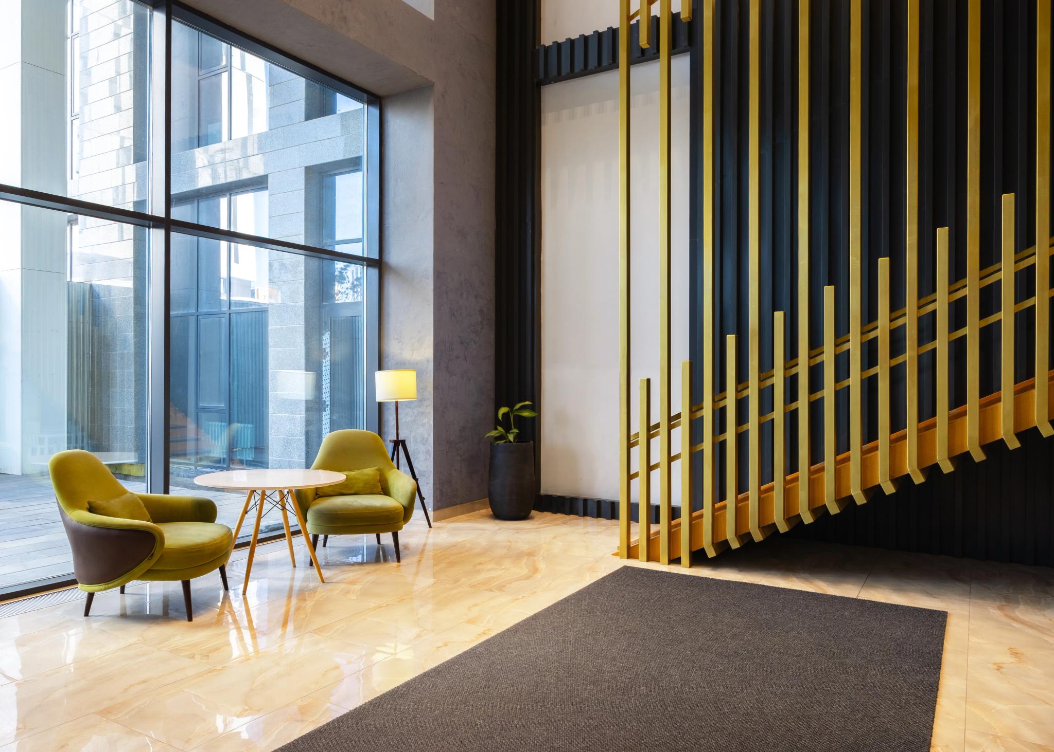 Tor'Re Astana hotel lobby with yellow armchairs and gold partition — luxury interior photography in Astana