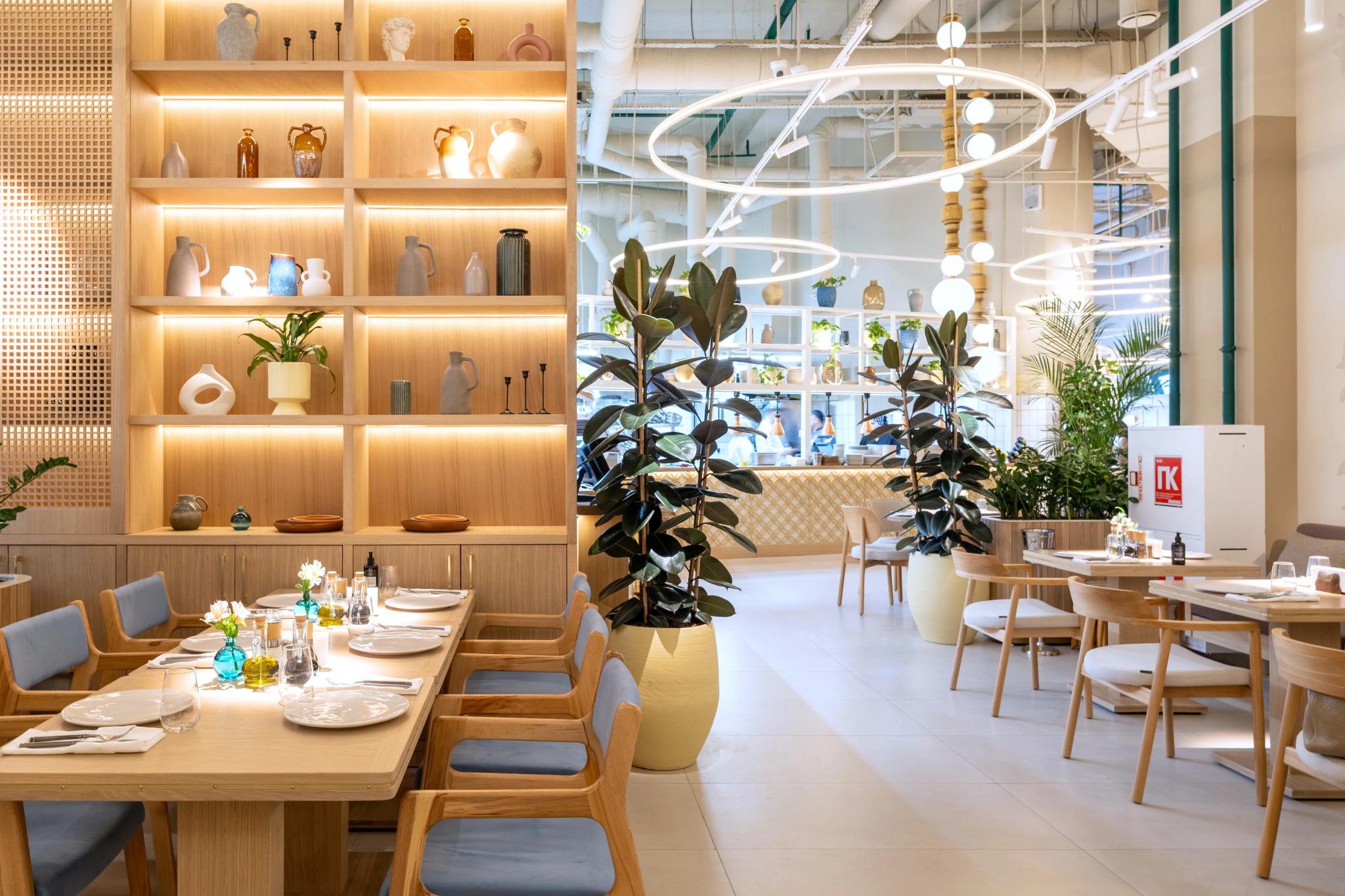 Modern restaurant interior of Syrovarnya in Astana with wooden furniture, illuminated shelving and green plants - professional interior photography Kazakhstan