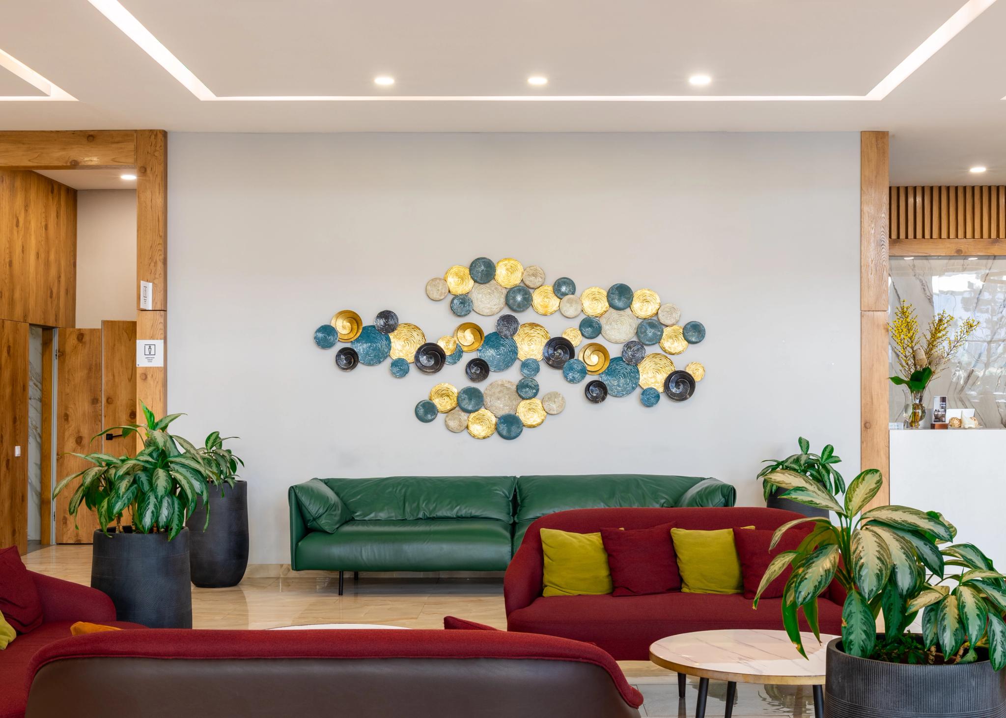 Tor'Re Astana hotel lobby with green sofa, decorative wall plates and plants - luxury interior photography in Astana