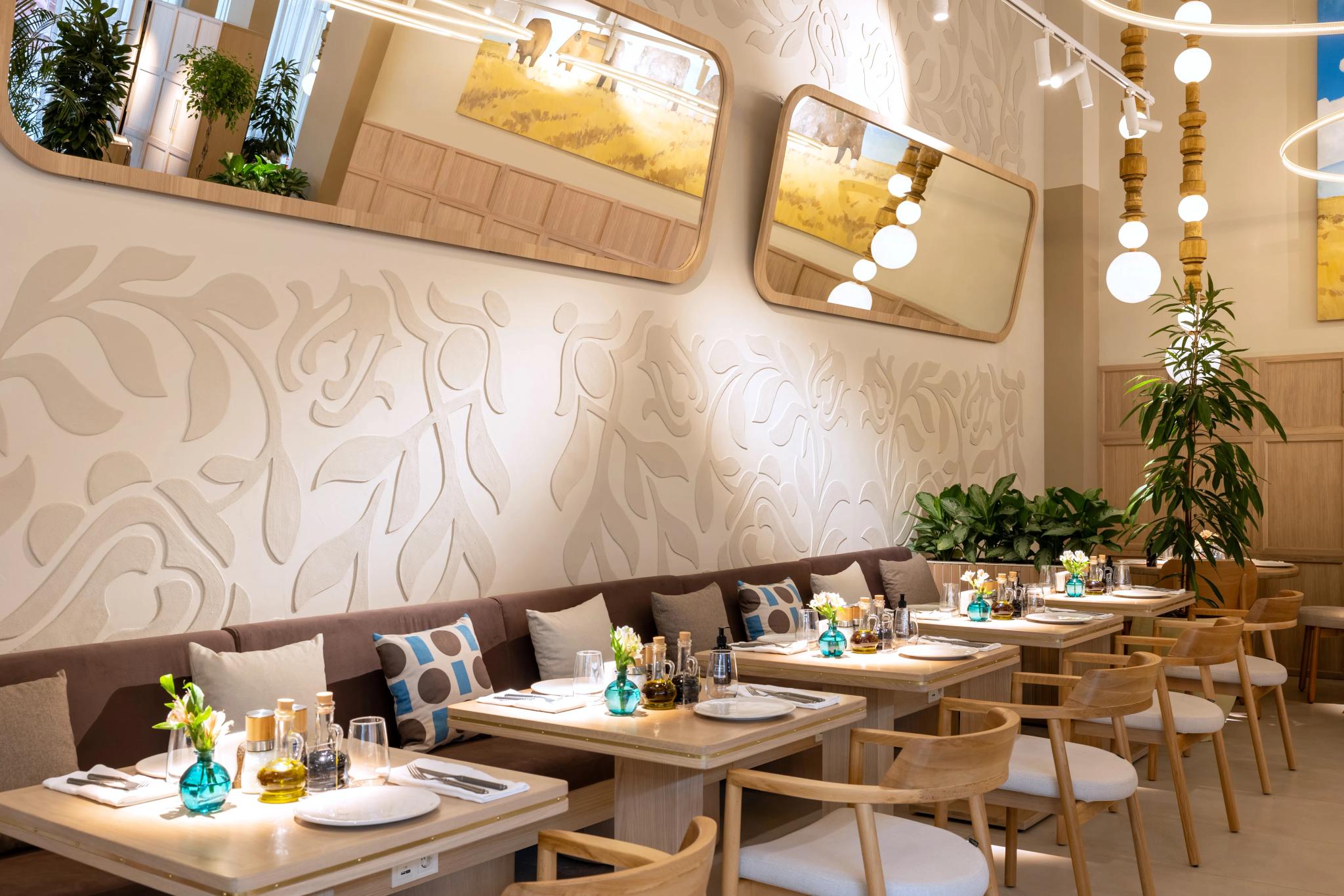 Interior photography of Syrovarnya restaurant in Astana: cozy dining area with upholstered banquette seating and wooden tables by professional photographer