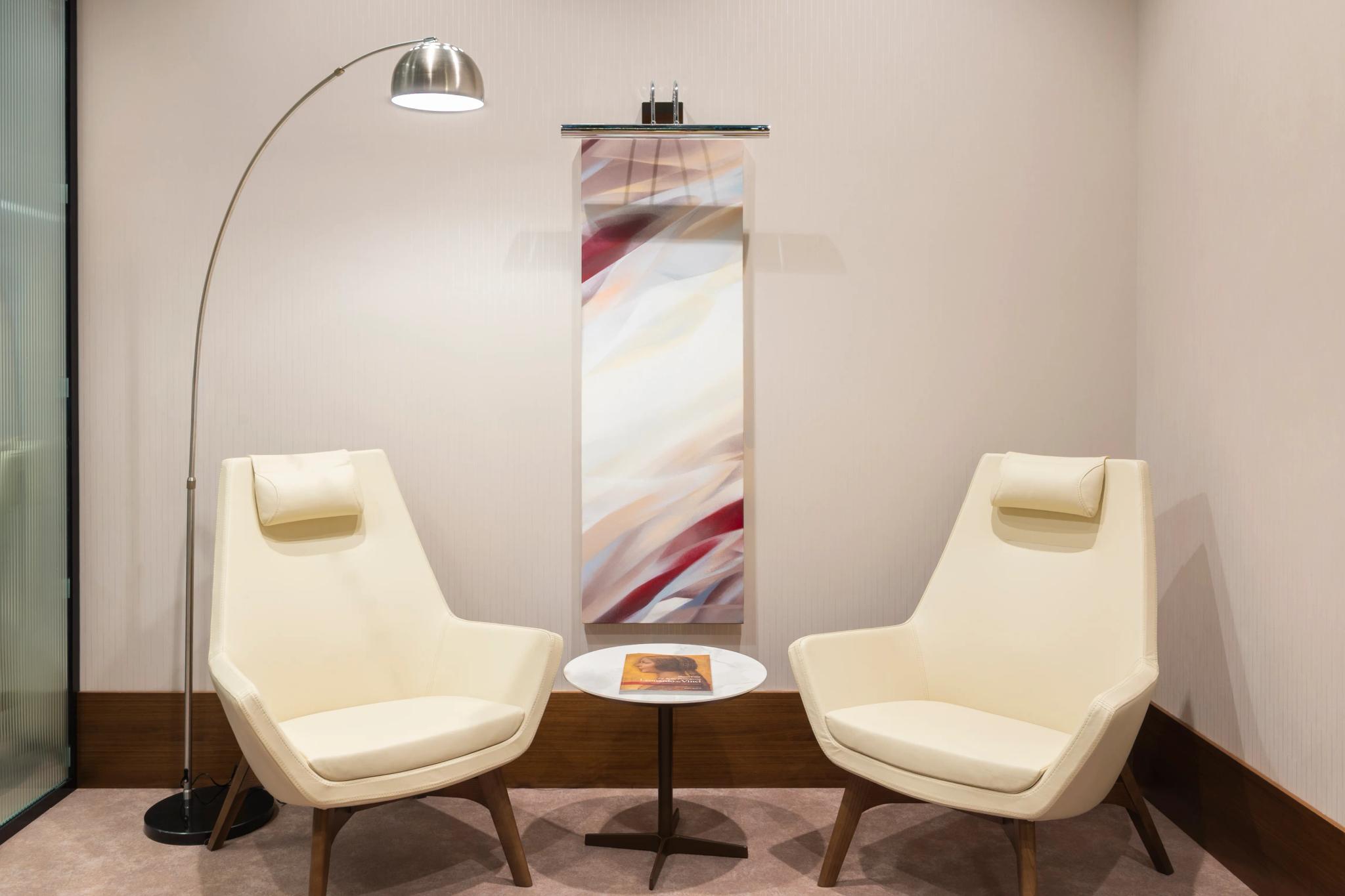Forte Bank Premier VIP lounge with cream armchairs and abstract art panel, luxury interior photography Astana