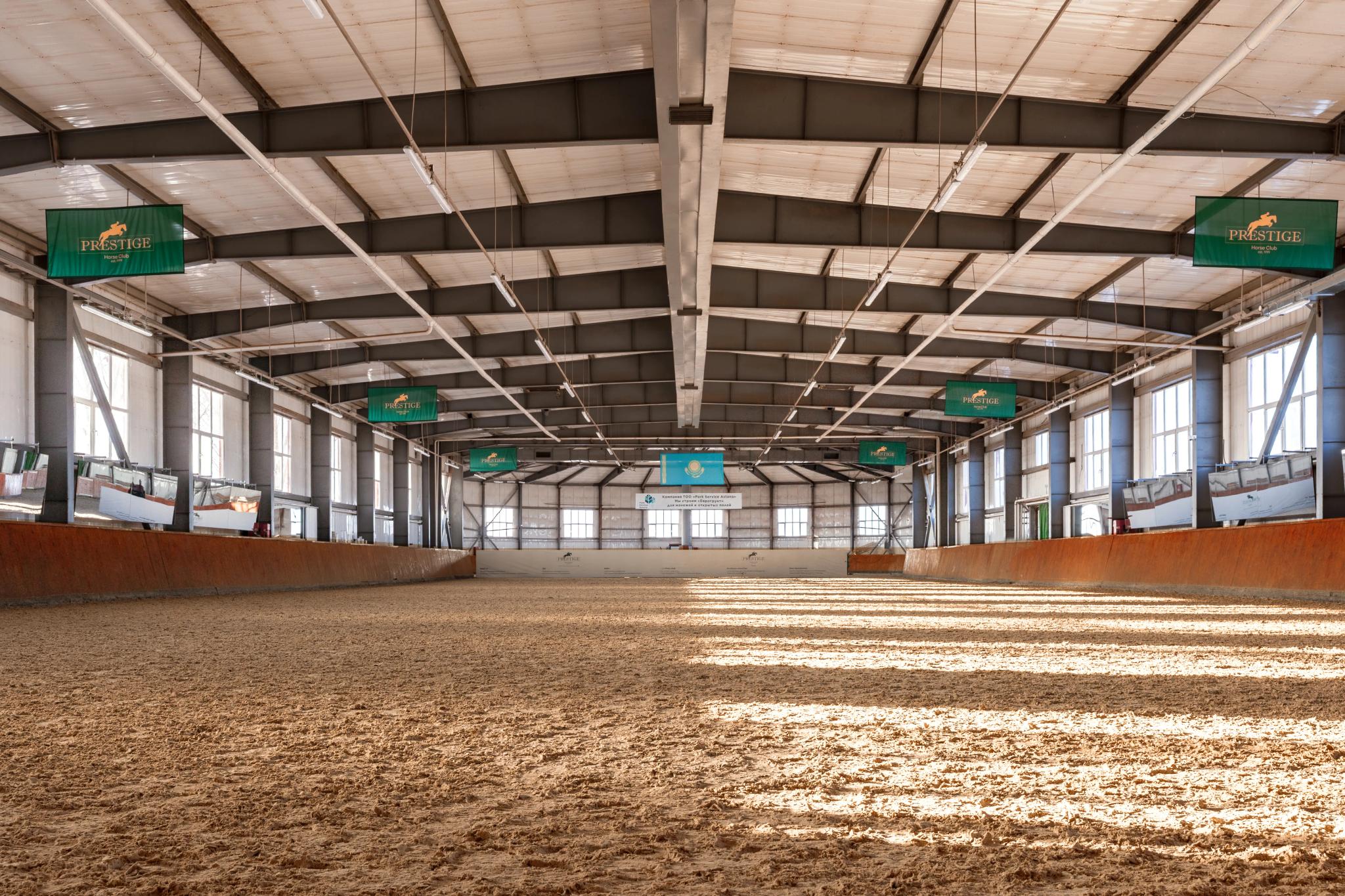 Interior of Prestige equestrian club riding arena in Astana with sand surface and modern architectural design