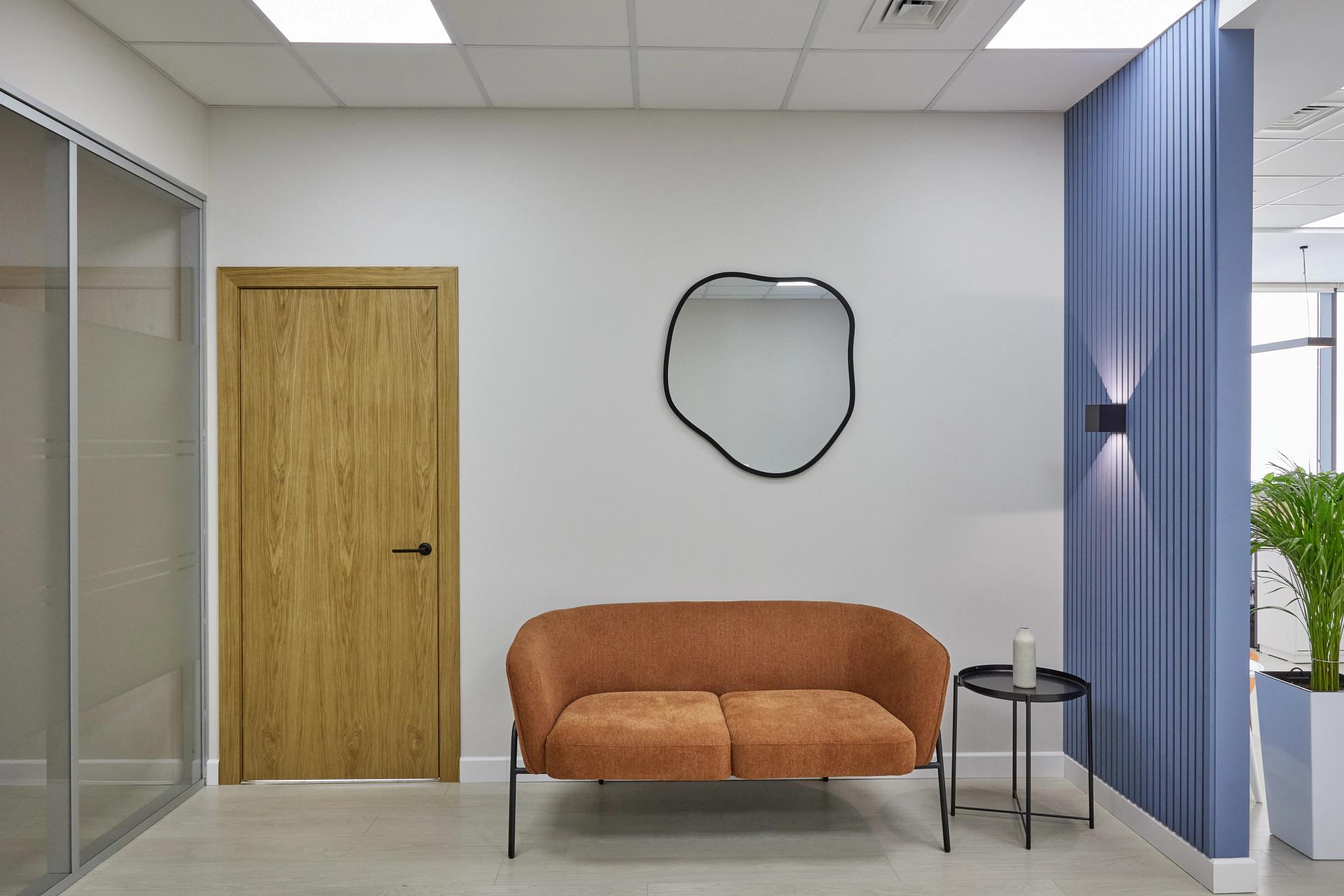 Modern Capital Tower office interior with brown sofa, round mirror and wooden door — commercial interior shoot by professional interior photographer Almaty