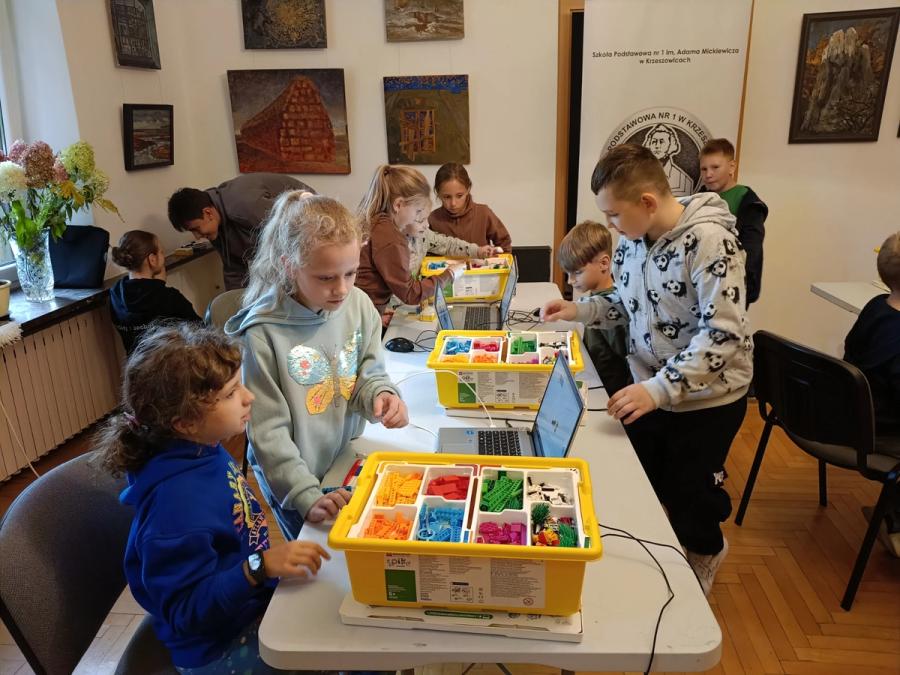 Trzy grupy dzieci budują kolejne modele z klocków