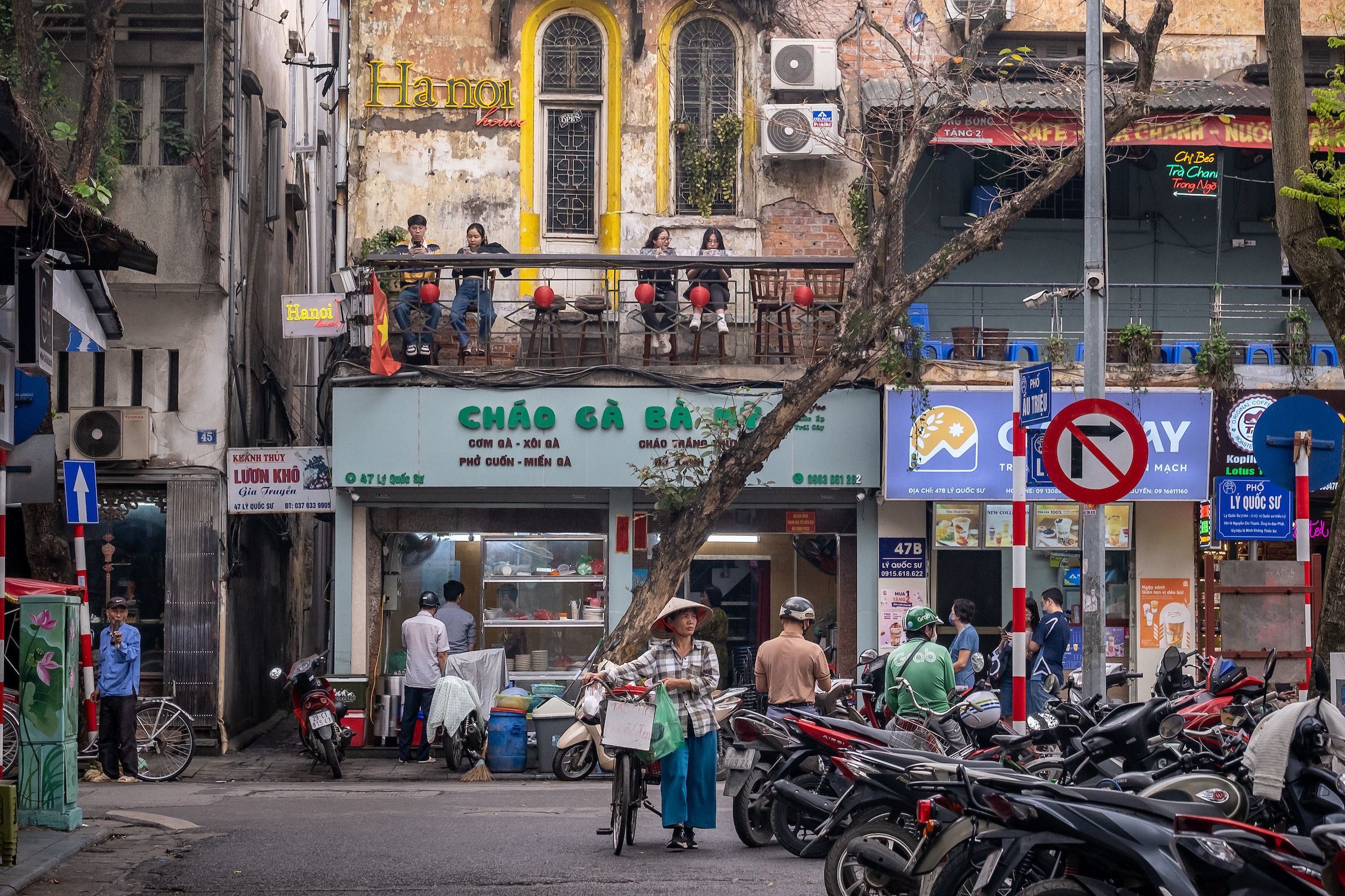 A man stands in the center holding a bicycle on a street in Vietnam