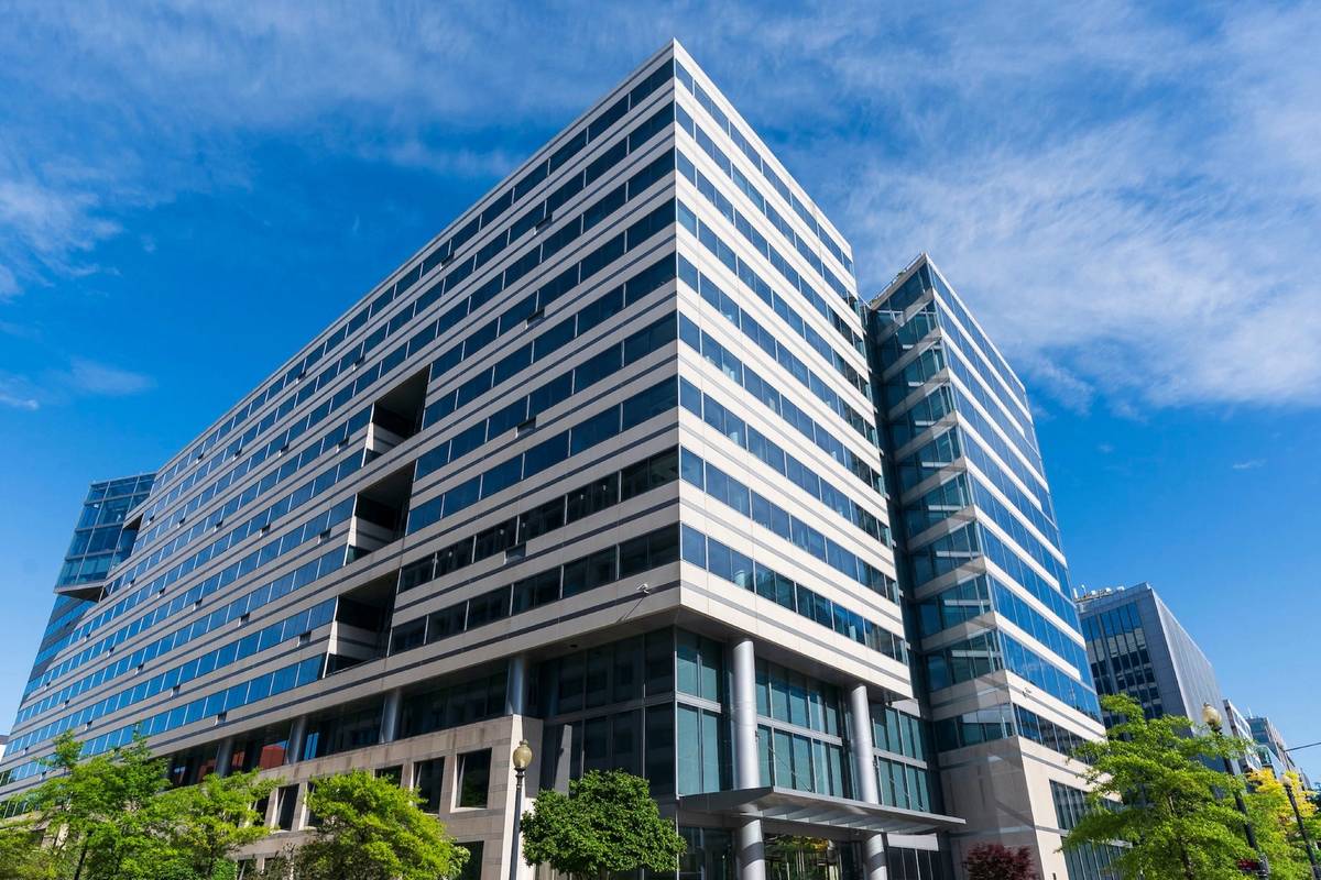A multistory building displayed with a glass windows and sharp perspective