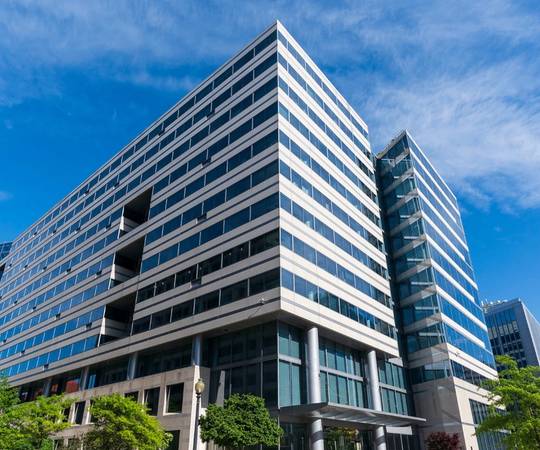 A multistory building displayed with a glass windows and sharp perspective