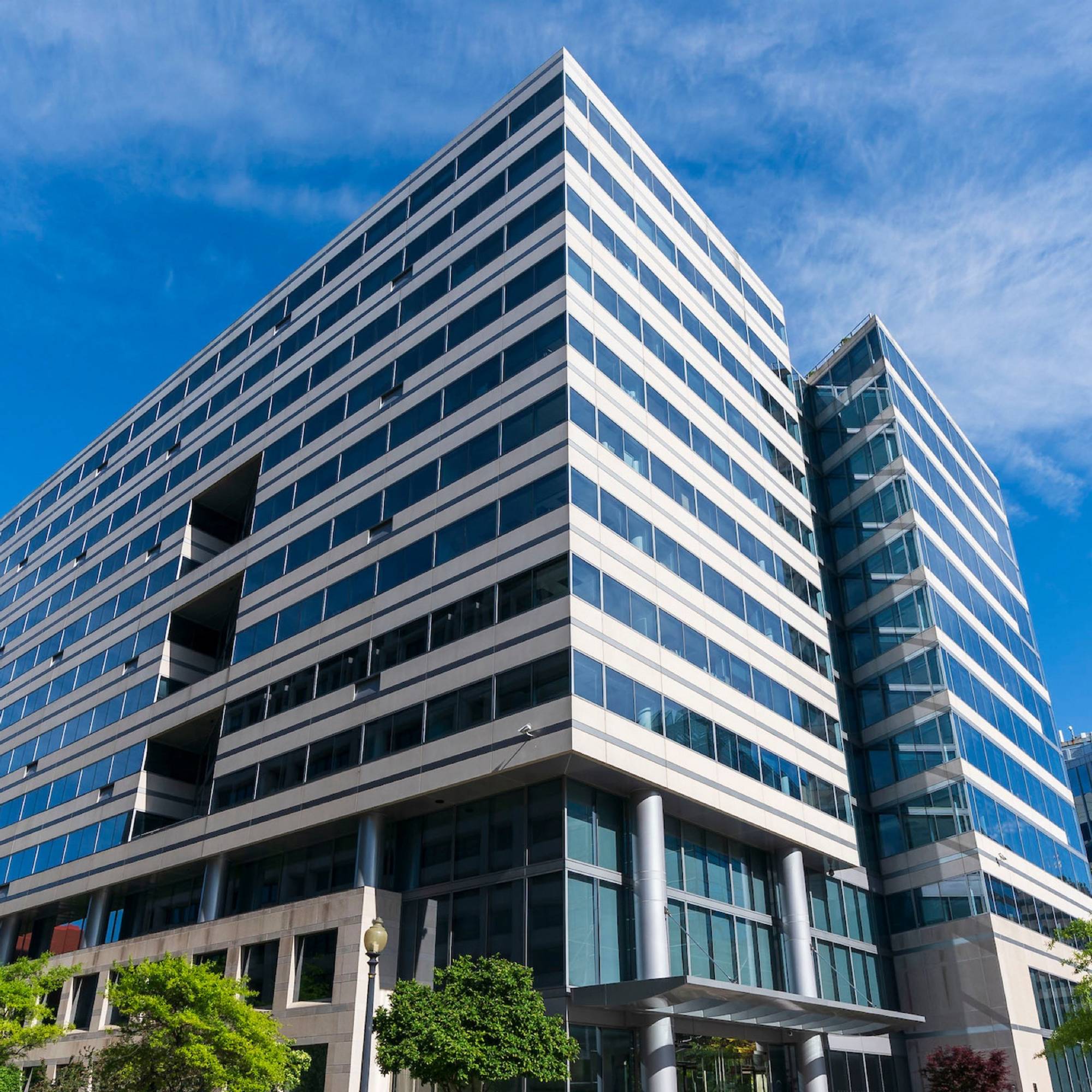 A multistory building displayed with a glass windows and sharp perspective