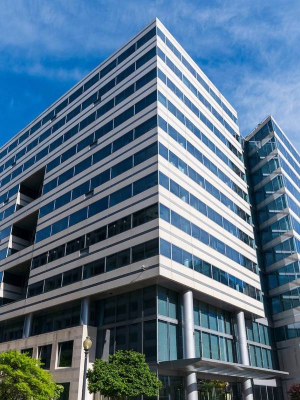 A multistory building displayed with a glass windows and sharp perspective
