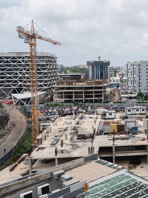 A cityscape of buildings under construction with two cranes visible