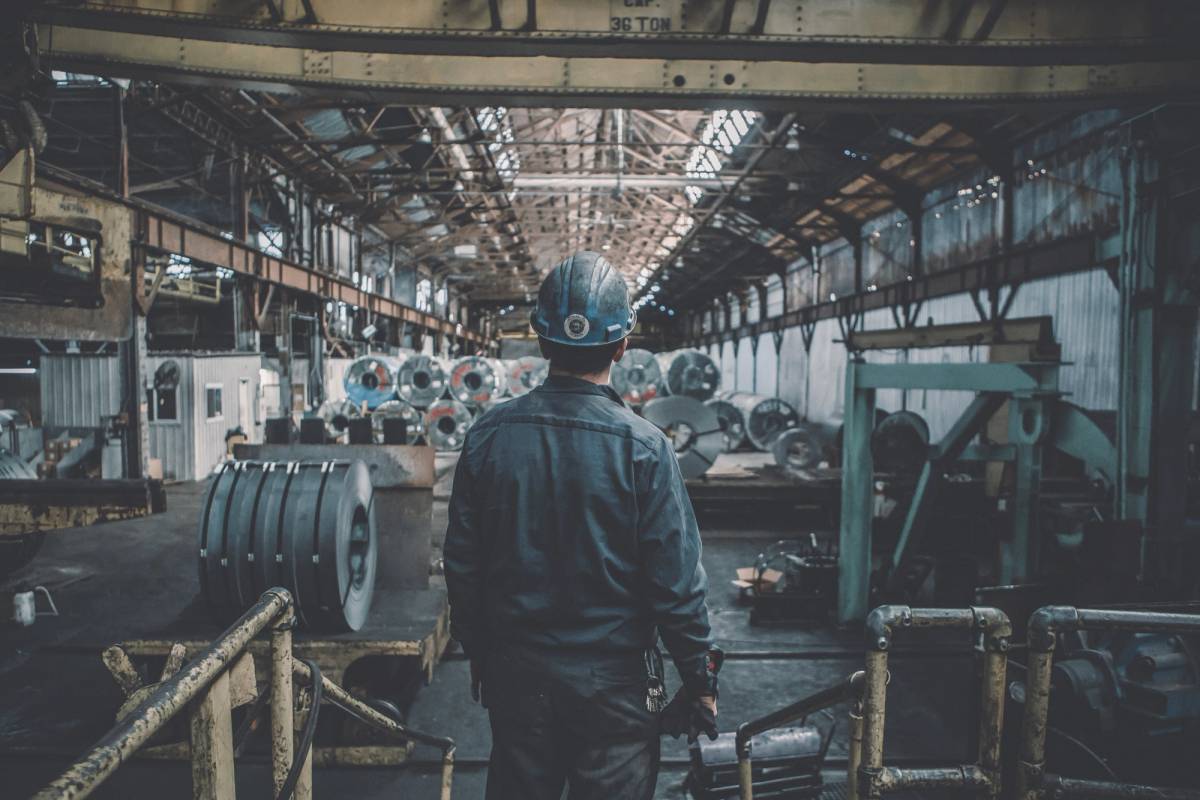 Worker in a hard hat inside a steel factory