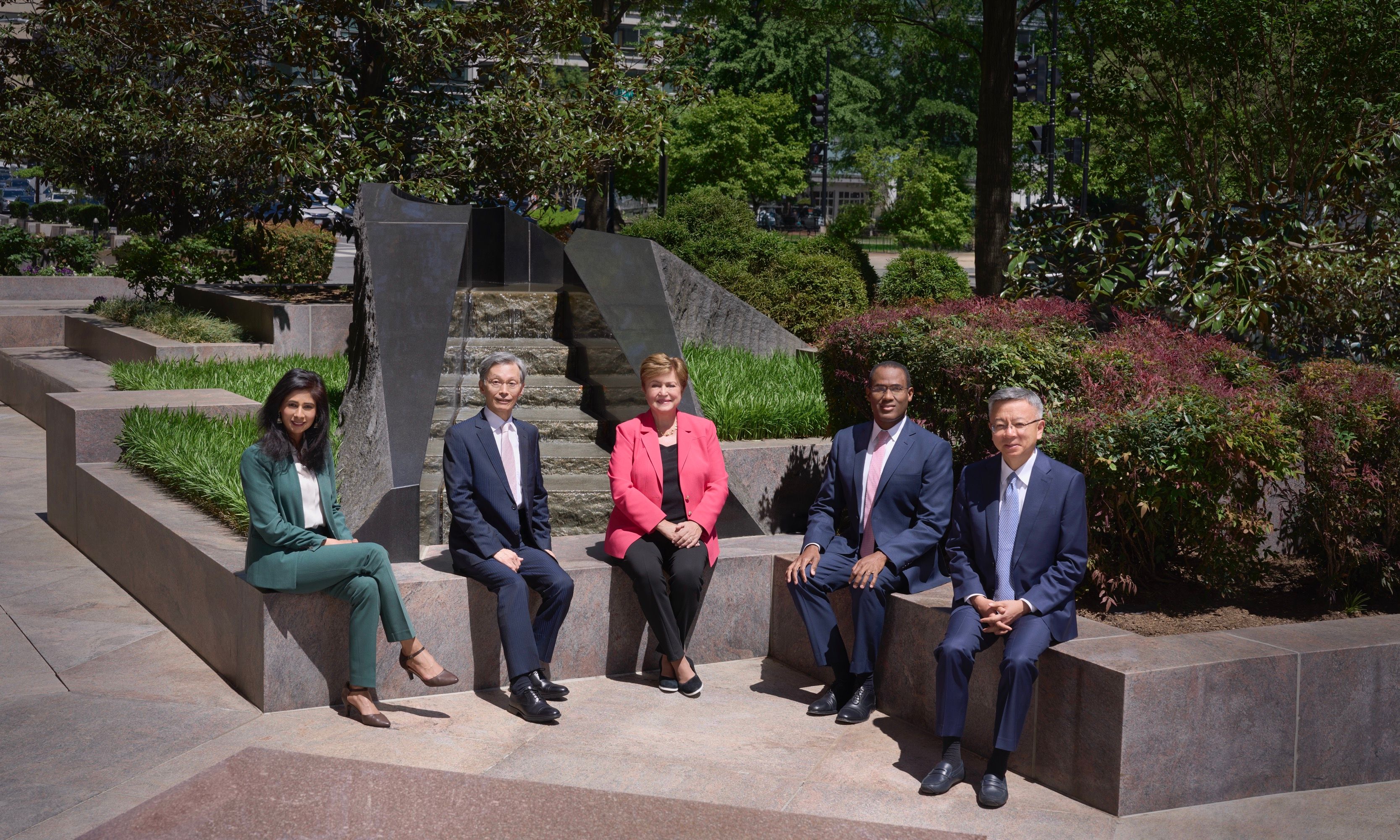 Gita Gopinath, Kenji Okamura, Kristalina Georgieva, Nigel Clarke and Bo Li are seated outdoors smiling and facing the camera