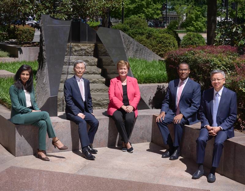 Gita Gopinath, Kenji Okamura, Kristalina Georgieva, Nigel Clarke and Bo Li are seated outdoors smiling and facing the camera