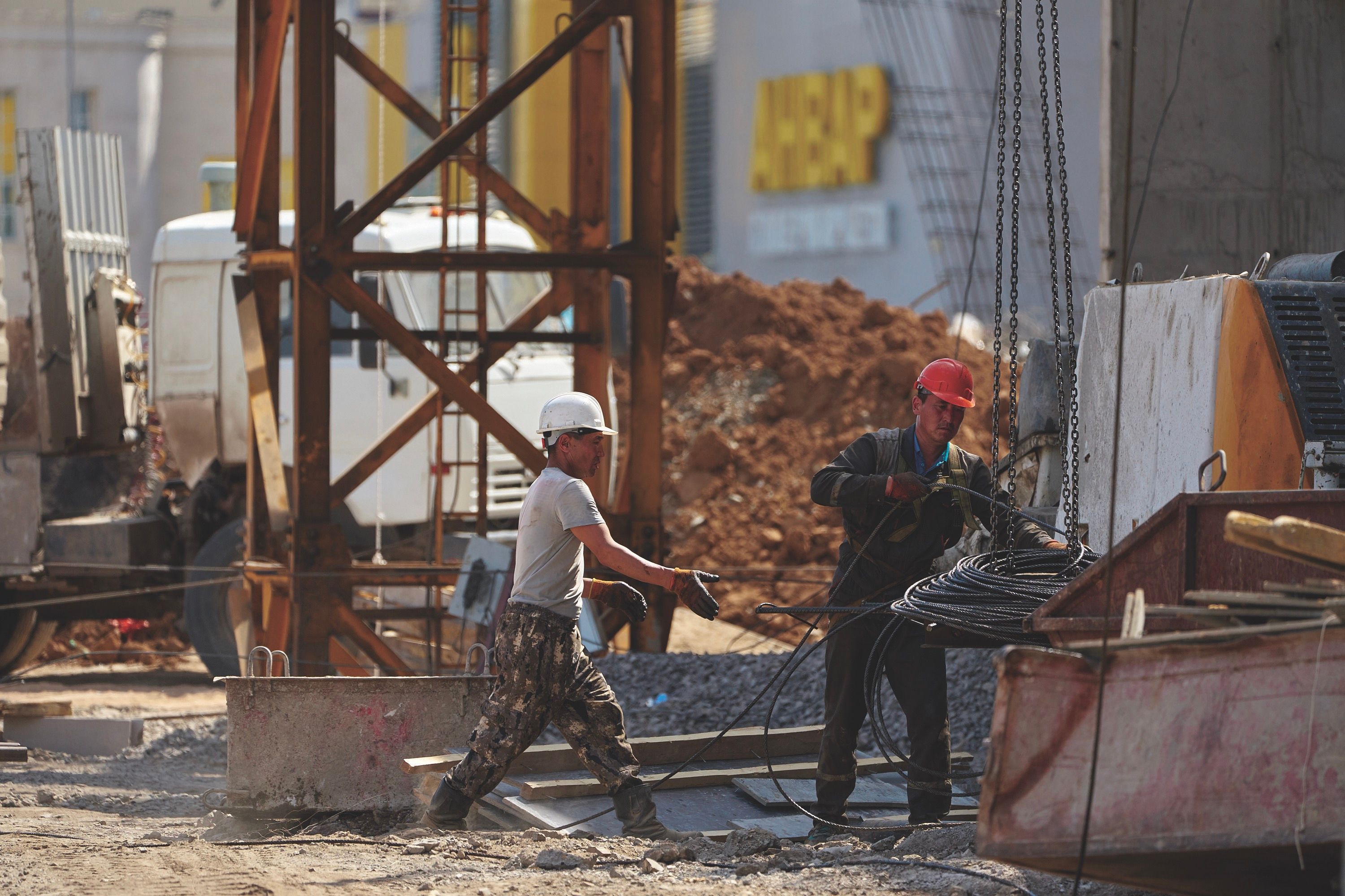 Two men wearing hard hats working in a construction area