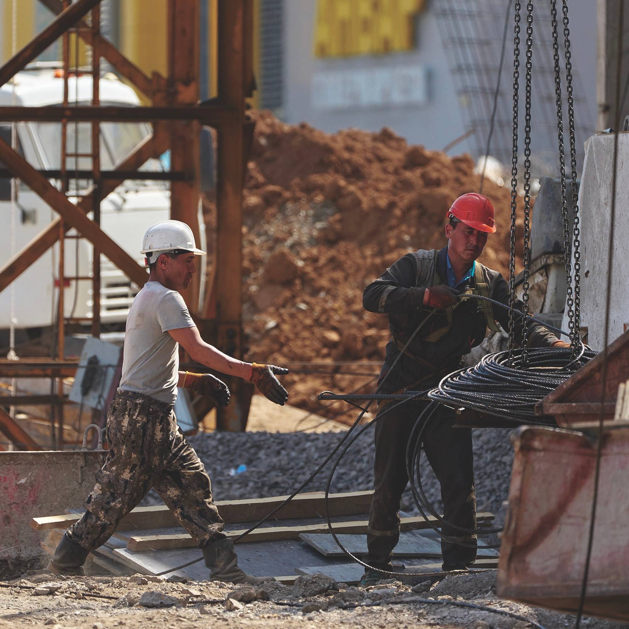 Two men wearing hard hats working in a construction area