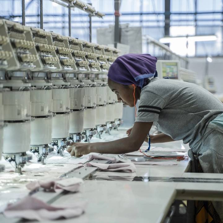 A woman works on a machine at a textile factory