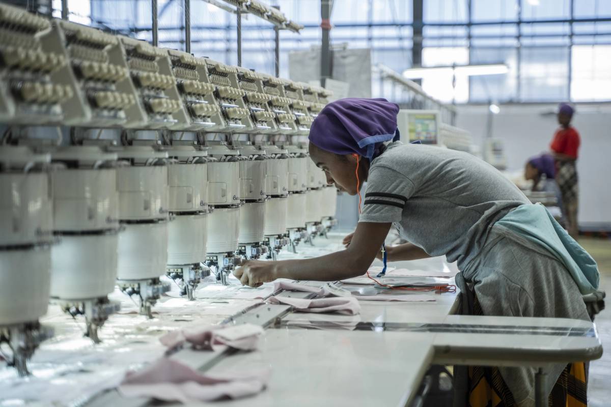 A woman works on a machine at a textile factory