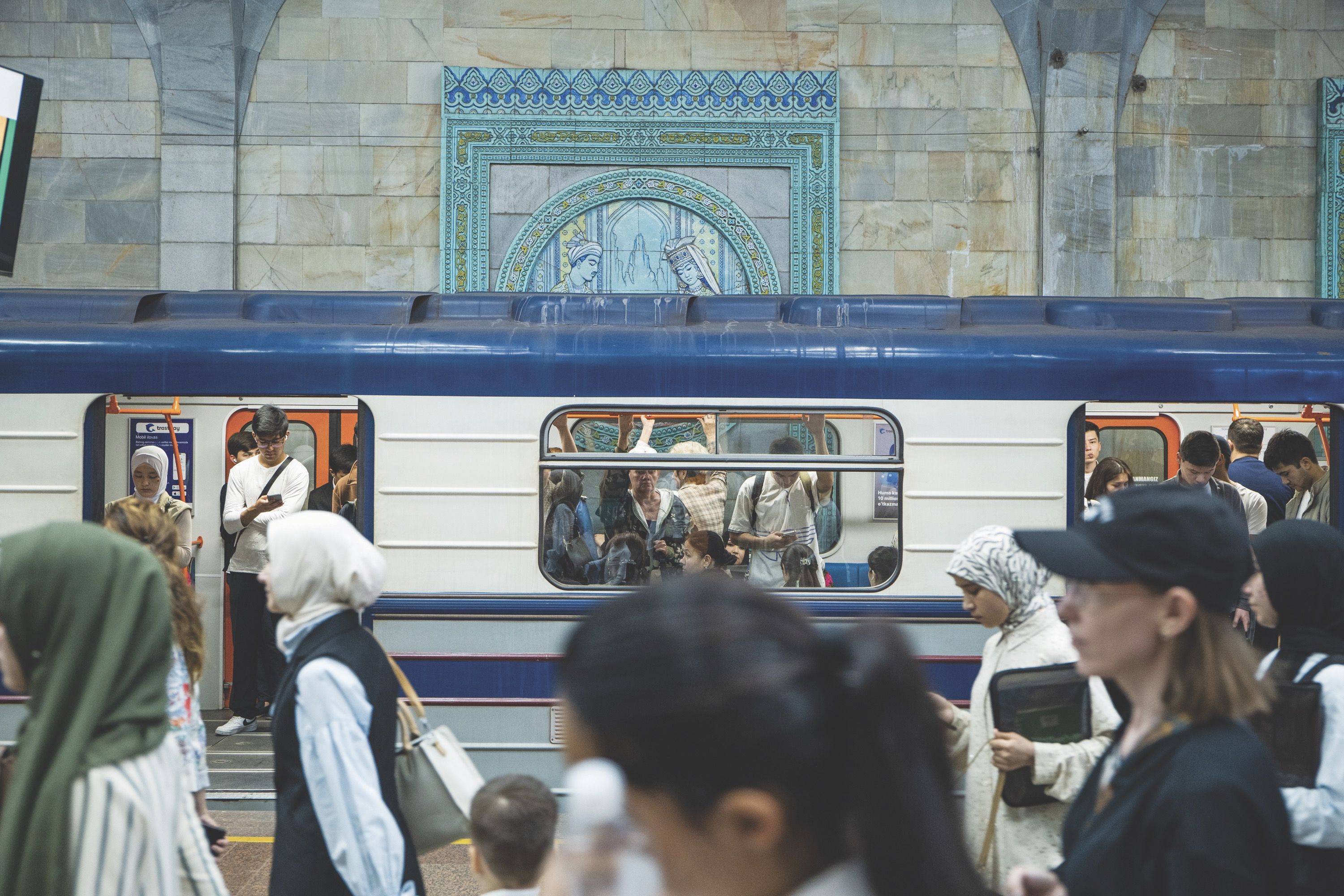 Crowded subway station with people boarding and exiting a train