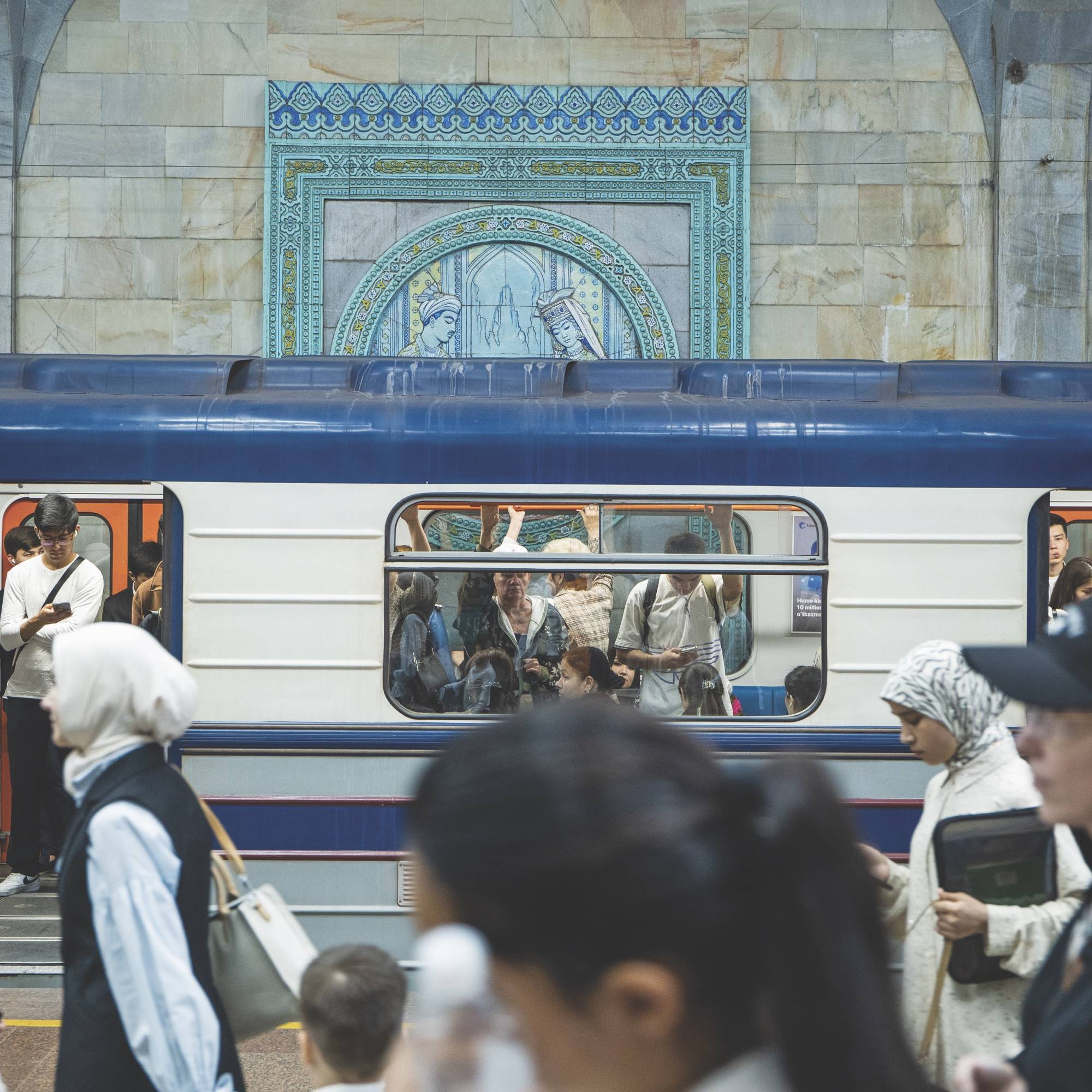 Crowded subway station with people boarding and exiting a train