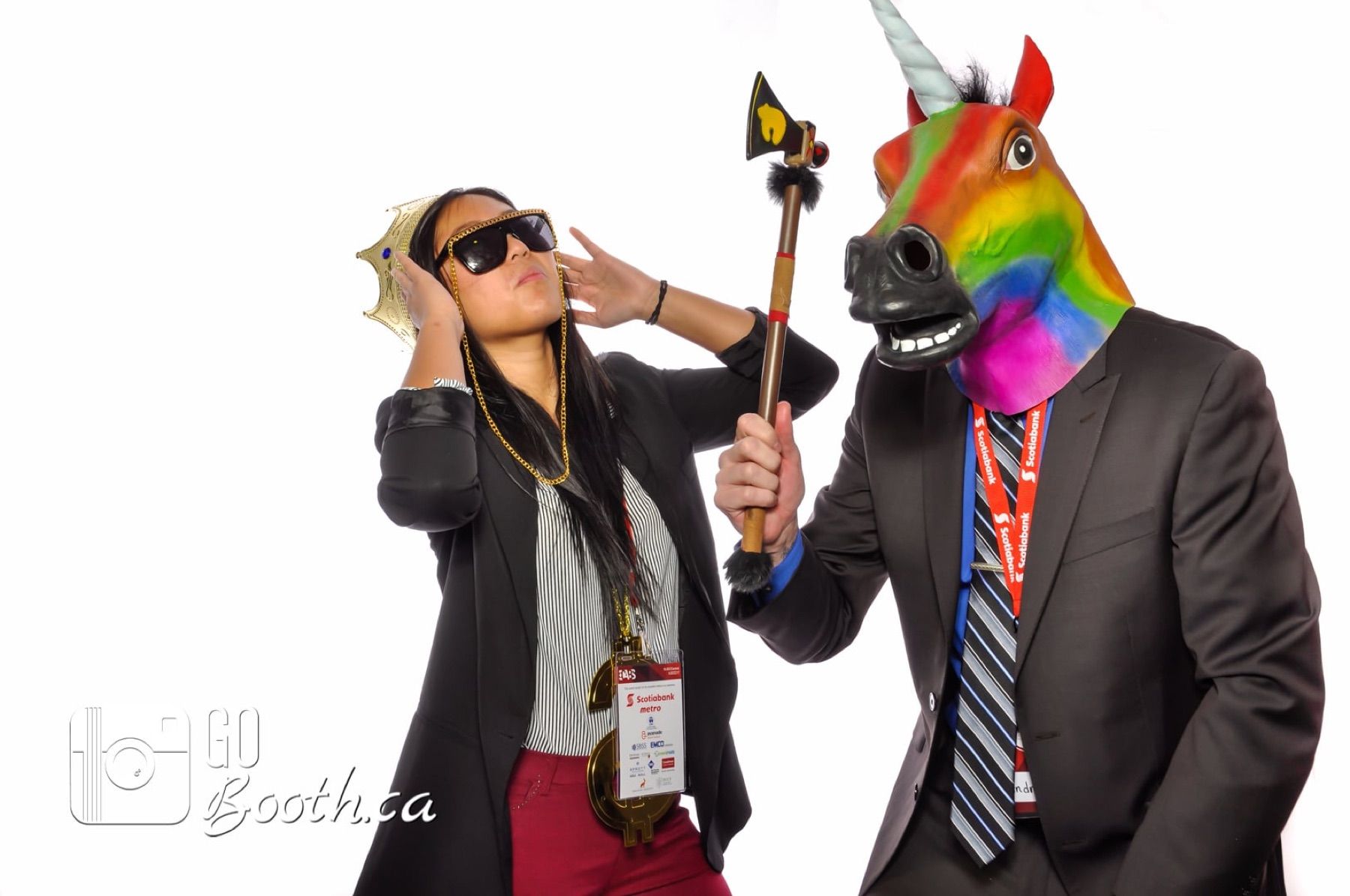 Colleague adjusting a rainbow unicorn mask on a coworker in the booth