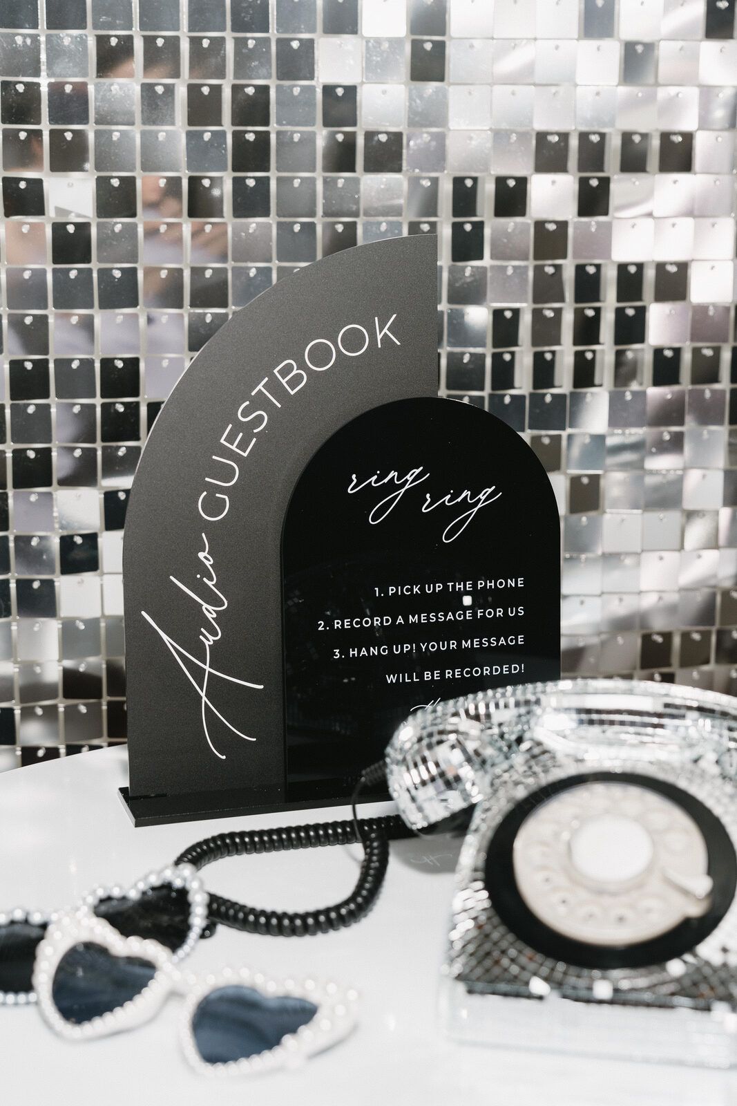 Silver sequin backdrop behind an audio guestbook table setup