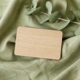 Visuel provisoire : Carte en bois clair, vue de dessus, sur un lin vert sauge