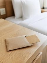 Visuel provisoire : Carte en carton glissée dans une pochette sur une table de chevet