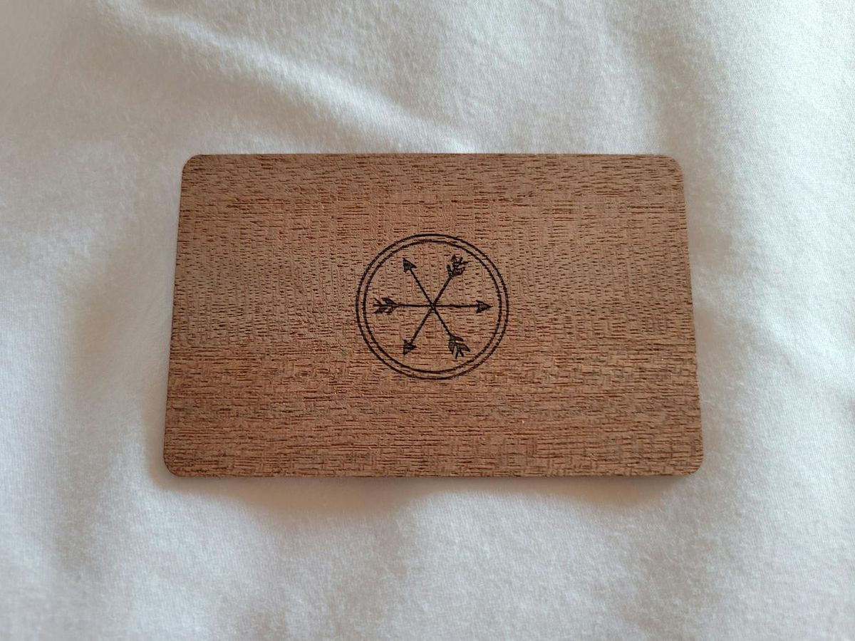 Carte en bois gravée d'un motif de boussole, posée sur un drap blanc (photo Unsplash provisoire)