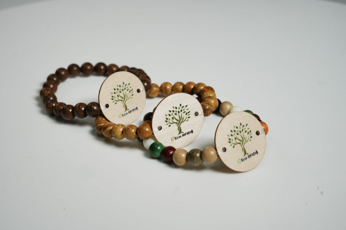 Trois bracelets RFID à billes en bois, chacun avec un médaillon rond en bois imprimé d'un logo