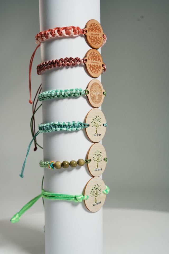 Six bracelets RFID tressés en tissu de couleurs variées, chacun avec un médaillon rond en bois gravé ou imprimé