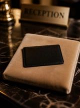 Visuel provisoire : Carte en simili cuir noir sur un coussin, au comptoir d'une réception